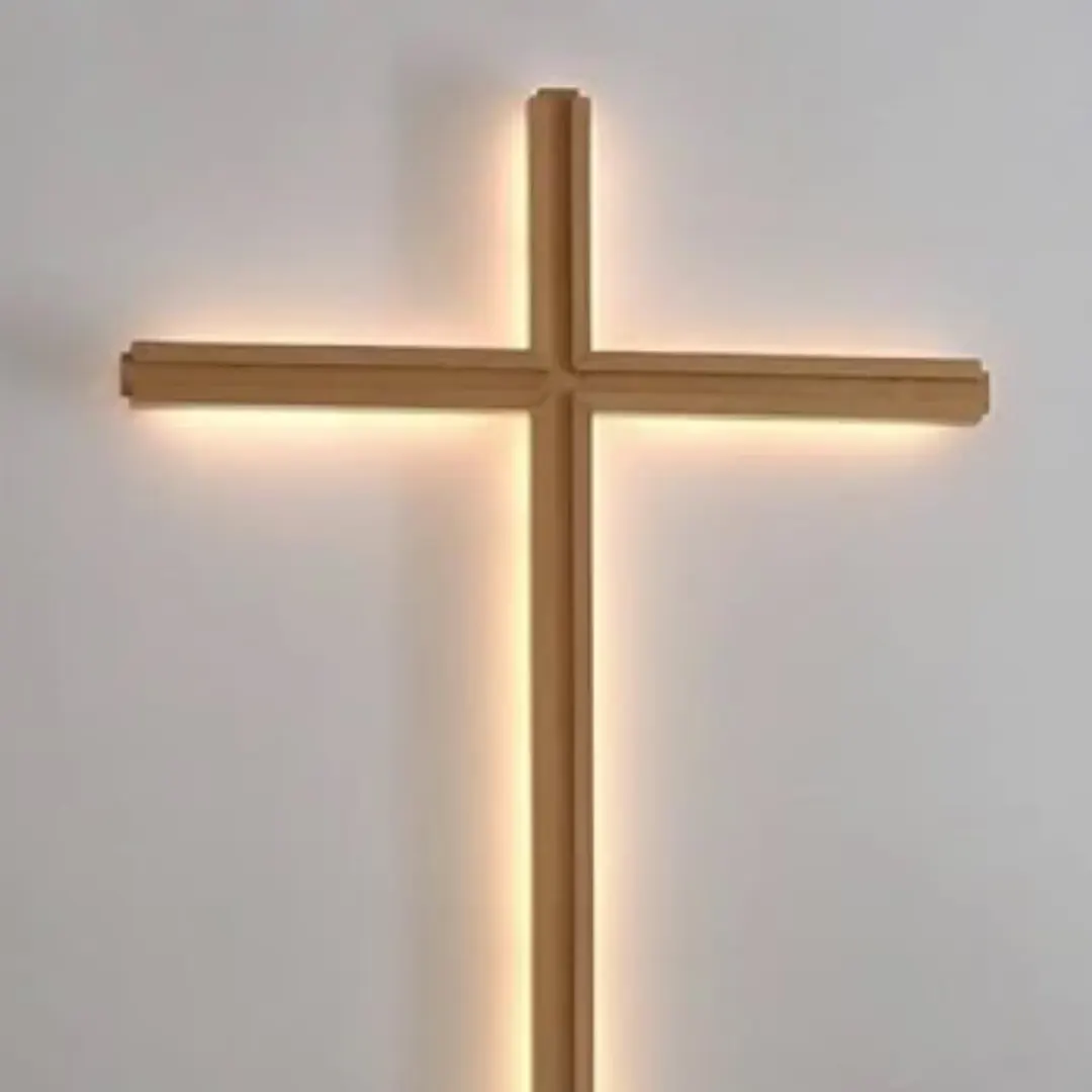 Das Bild zeigt ein beleuchtetes Kreuz vor einer weißen Wand aus dem Innenraum der FeG Neuallermöhe.